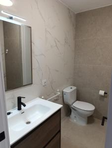 a bathroom with a sink and a toilet and a mirror at Apartamento Ideal in Alaior +6 photos