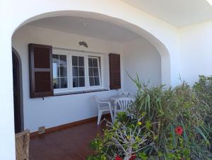 a patio with a window and a table and chairs at Apartamento Ideal in Alaior