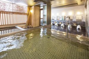 a large pool of water in a bathroom with sinks at HOTEL MYSTAYS Kanazawa Castle in Kanazawa