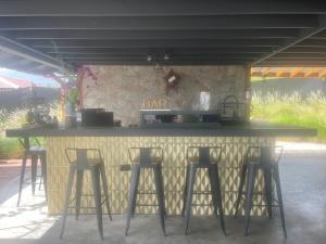a bar with four bar stools in front of it at Pampagrass View in Santa Isabel