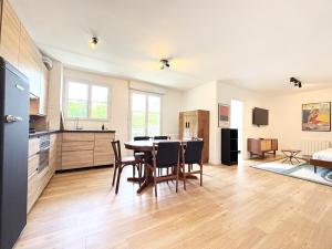 eine Küche und ein Esszimmer mit Tisch und Stühlen in der Unterkunft Le Genêt Disney 15min Train 8min Paris Parking in Bussy-Saint-Georges