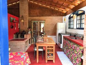 a kitchen with a wooden table and a refrigerator at Chalé Frida Kahlo in Campinas