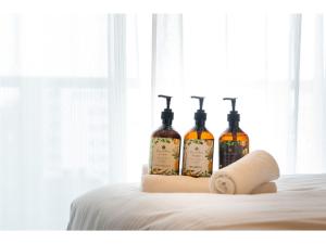 three bottles of wine sitting on top of a bed at Hotel Living Inn Kenchoumaeeki - Vacation STAY 03409v in Naha