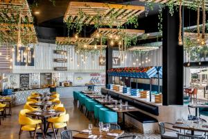 ein Restaurant mit Tischen, Stühlen und Kronleuchtern in der Unterkunft Fiesta Americana Riviera Nayarit Resort All Inclusive & Spa in Nuevo Vallarta