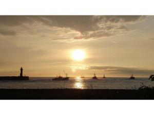 紋別市にあるHotel Okhotsk Palace - Vacation STAY 24136vの灯台と水上のボートのある夕日