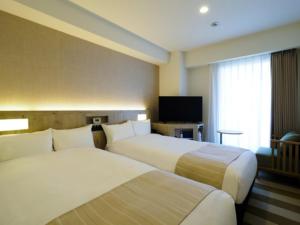 a hotel room with two beds and a flat screen tv at Far East Village Hotel Yokohama - Vacation STAY 27895v in Yokohama