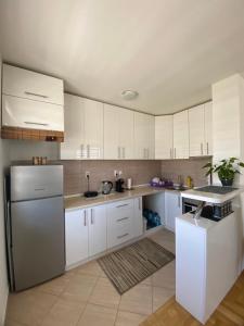 a kitchen with white cabinets and a refrigerator at Lake View EIA in Lukavica