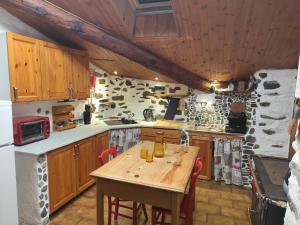 a kitchen with wooden cabinets and a wooden table at Tipica casa di montagna nelle Valli di Lanzo in Groscavallo