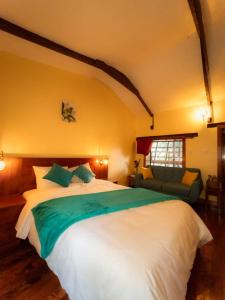 QuillabambaにあるEcoterra Inka Lodgeの大きな白いベッドとソファのある寝室