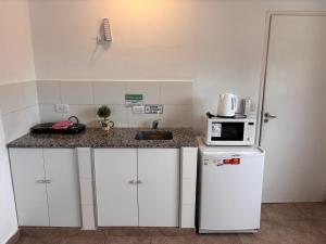 a small kitchen with a sink and a microwave at Soya departamentos A in Junín
