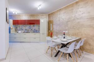 Un comedor con una mesa y sillas blancas. en Modern 3 bedroom Maisonette in the heart of Swieqi, en Is-Swieqi