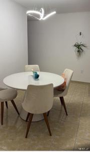einen weißen Tisch und Stühle in einem Zimmer in der Unterkunft Apartmento São João in Campina Grande