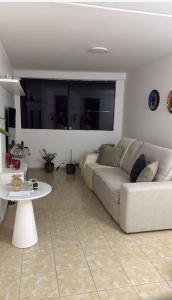 ein Wohnzimmer mit Sofa und Tisch in der Unterkunft Apartmento São João in Campina Grande + 1 Foto