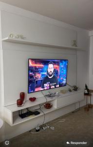 ein Flachbildfernseher auf einem weißen Entertainment-Center in der Unterkunft Apartmento São João in Campina Grande