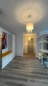 a living room with a chandelier and a hallway at Lapus Residence Apartament in Craiova