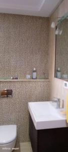 a bathroom with a sink and a toilet and a mirror at Sousse in Hammam Sousse