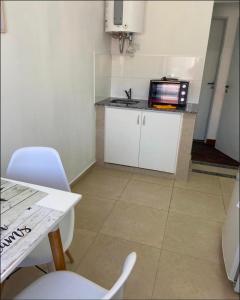 a small kitchen with a microwave and a table and chairs at Soya Departamentos PB A in Junín +5 photos