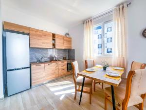 a kitchen with a table and a refrigerator at Cozy Lagoon Apartment in Lezhë