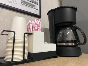 a coffee maker and a stack of plates on a counter at Matsukisou"children under 6 years old not allowed" - Vacation STAY 36205v in Beppu