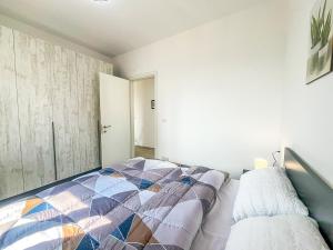 a bedroom with a bed with a colorful quilt at Cozy Lagoon Apartment in Lezhë +16 photos