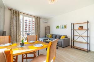 a dining room with a table and a couch at Cozy Lagoon Apartment in Lezhë