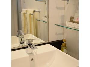 a bathroom with a white sink and a mirror at Midosuji Hotel - Vacation STAY 41579v in Osaka +6 photos