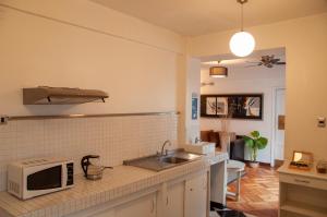 a kitchen with a sink and a microwave at Tremo Patio Bellavista in Santiago +127 photos