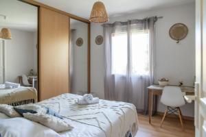 a bedroom with two beds and a desk and a window at Jolie maison LE TEICH bassin Park/wifi in Le Teich