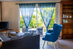 a living room with a couch and chairs in front of a window at Jolie maison LE TEICH bassin Park/wifi in Le Teich