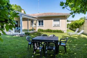 a table and chairs in the yard of a house at Jolie maison LE TEICH bassin Park/wifi in Le Teich