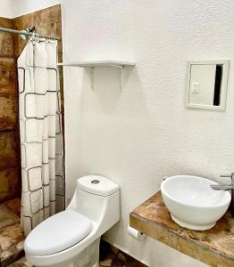 a bathroom with a white toilet and a sink at Quinta Colinas Oaxtepec in Oaxtepec +8 photos