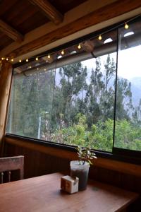 einen Tisch in einem Zimmer mit einem großen Fenster in der Unterkunft Cabaña rodeada de naturaleza en Ollantaytambo in Ollantaytambo + 4 Fotos