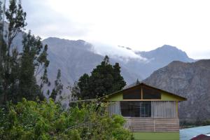 ein kleines Haus mit Bergen im Hintergrund in der Unterkunft Cabaña rodeada de naturaleza en Ollantaytambo in Ollantaytambo