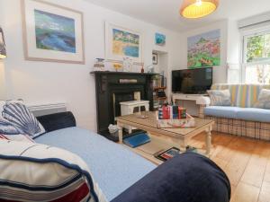 a living room with a blue couch and a tv at 2 The Cottages in Ludgvan