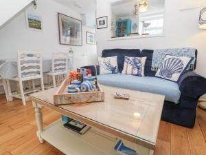 a living room with a blue couch and a coffee table at 2 The Cottages in Ludgvan