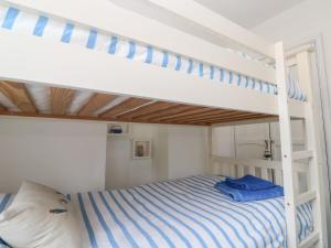 a bedroom with a bunk bed with blue and white stripes at 2 The Cottages in Ludgvan