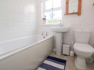 a white bathroom with a toilet and a sink at 2 The Cottages in Ludgvan +23 photos