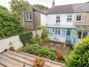 a house with a garden with a wooden bench at 2 The Cottages in Ludgvan