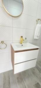 un bagno bianco con lavandino e specchio di Vila Skodupė 