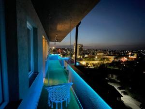 a balcony with a view of a city at night at Aria Apartment in Prishtinë