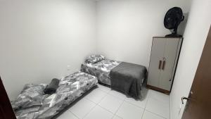 a room with two beds and a dresser in it at Apto Inteiro no centro de Caruaru in Caruaru +1 photo