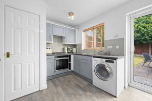 eine Küche mit Waschmaschine und Trockner in der Unterkunft Three Bedroom House by Brookland Stays Serviced Accommodation Short Lets Wigan with Free WiFi in Hindley