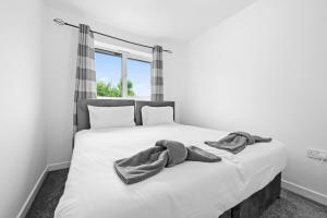 ein weißes Bett mit zwei Handtüchern darauf in der Unterkunft Three Bedroom House by Brookland Stays Serviced Accommodation Short Lets Wigan with Free WiFi in Hindley