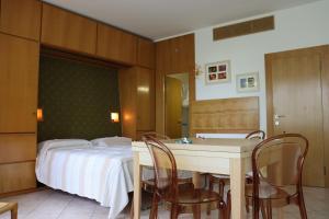 a bedroom with a bed and a table and chairs at Monika Holiday 619 Green Garda Lake in Garda
