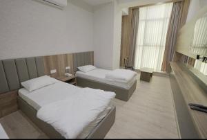 a hotel room with two beds and a window at Lara Hotel in Duhok