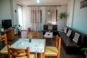 a living room with a couch and a table and chairs at Gega's Apartment in Gjirokastër