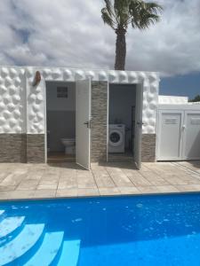 a bathroom with a toilet next to a pool at Casa Dos Jotas in Costa Calma