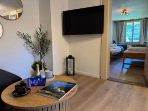 a living room with a table and a flat screen tv at River 4-Kissed Retreat with Iconic Jungfraujoch View in Interlaken +11 photos