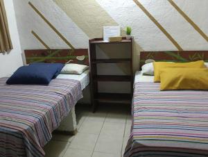 two beds sitting next to each other in a room at Hotel Hostal Teresa in Zipolite