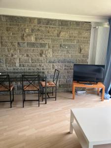a living room with chairs and a table and a brick wall at Taunus Wohnen und Arbeiten mit eigener Terrasse in Friedrichsdorf